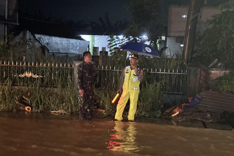 Anggota Babinsa dan Anggota Polsek Tulis melakukan pengaturan lalulintas di wilayah Desa Beji terkait terjadinya banjir di Kec.Tulis